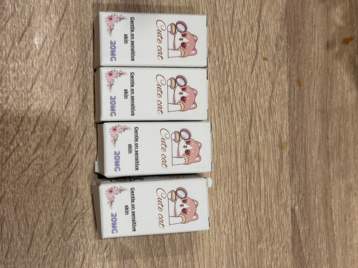 Four white cat treatment boxes labeled 20MG arranged together on a wooden surface.